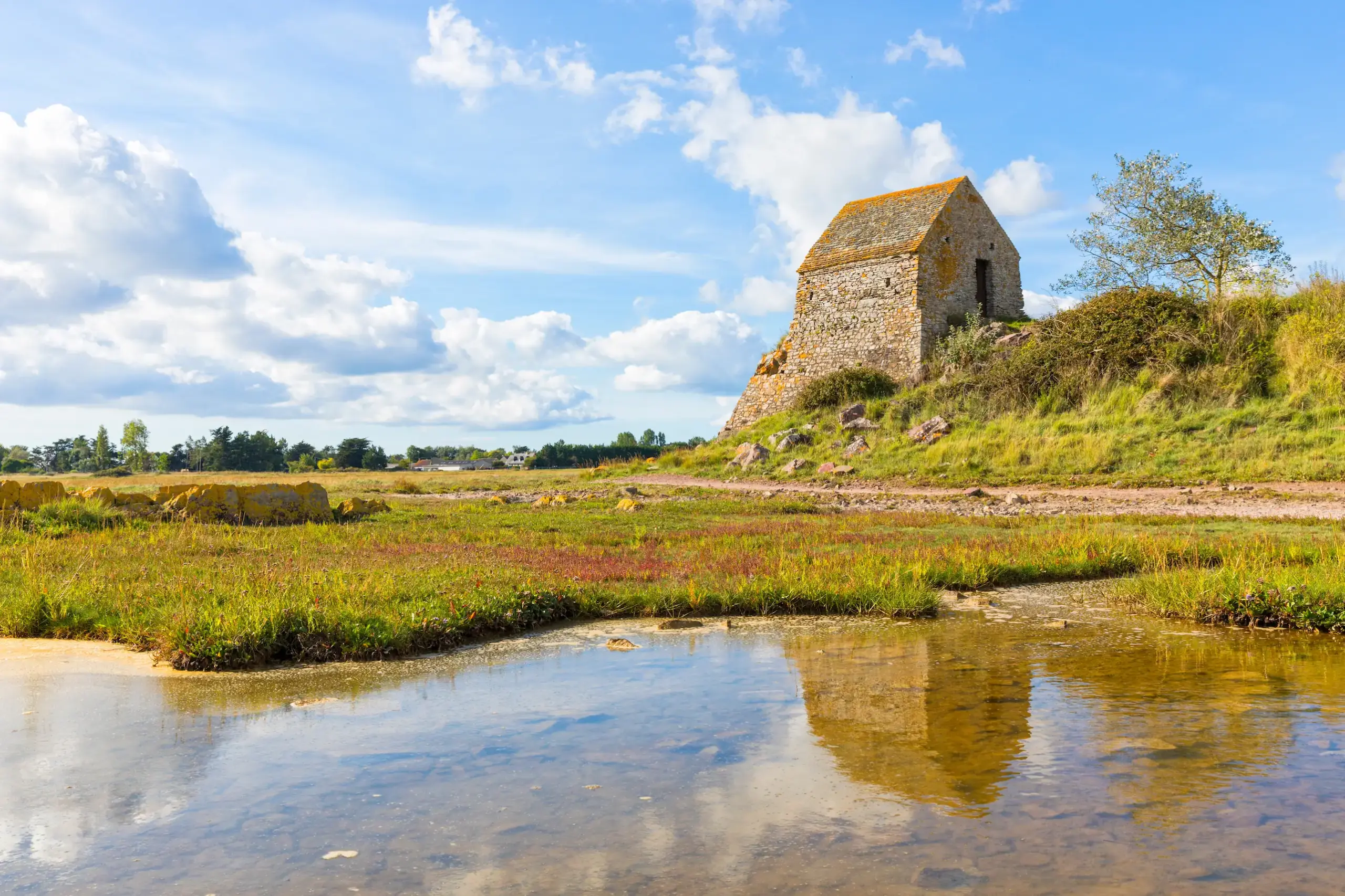 Petite maison en pierre au bord d’un marais