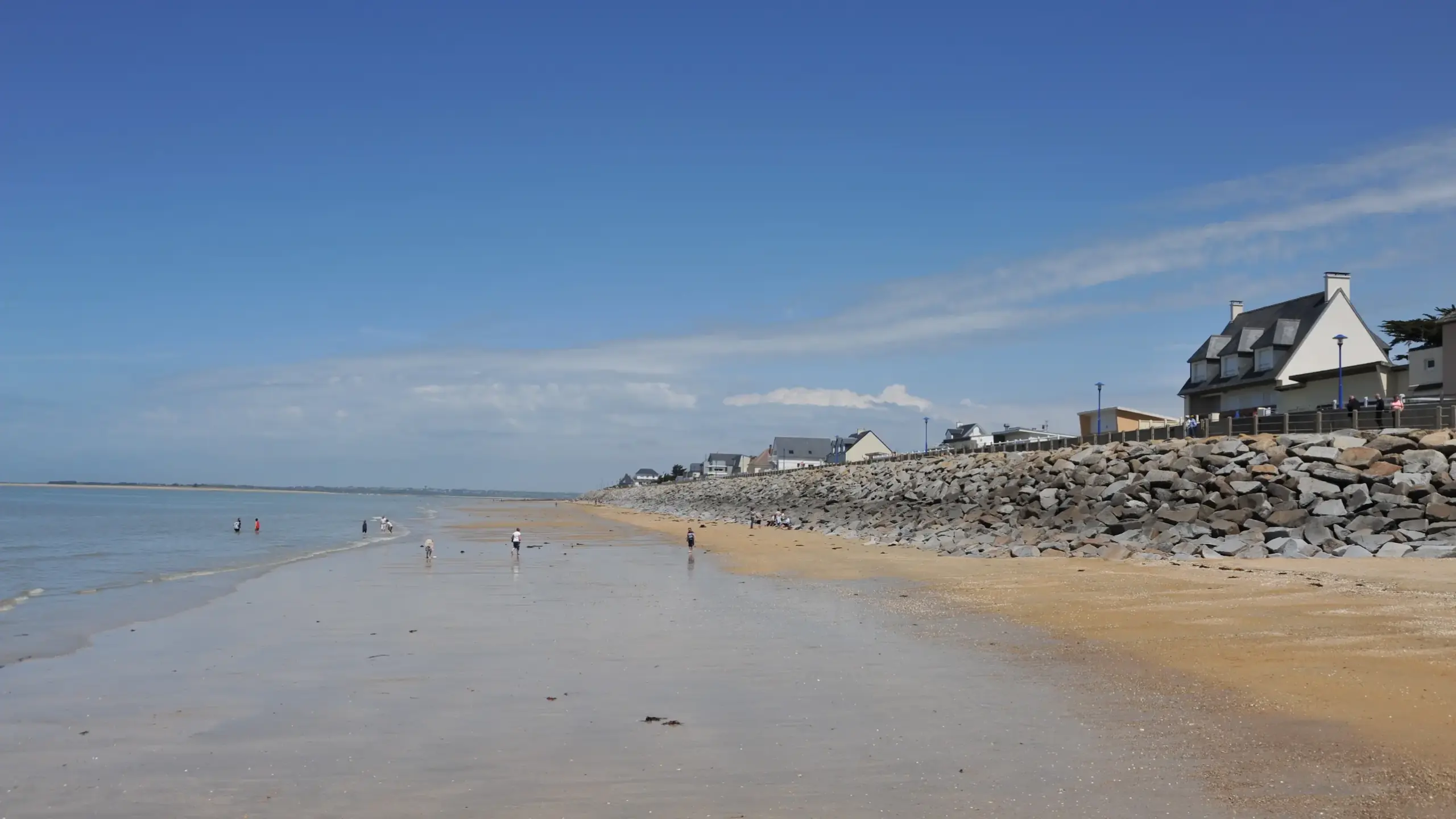 Plage calme à marée basse et maisons côtières